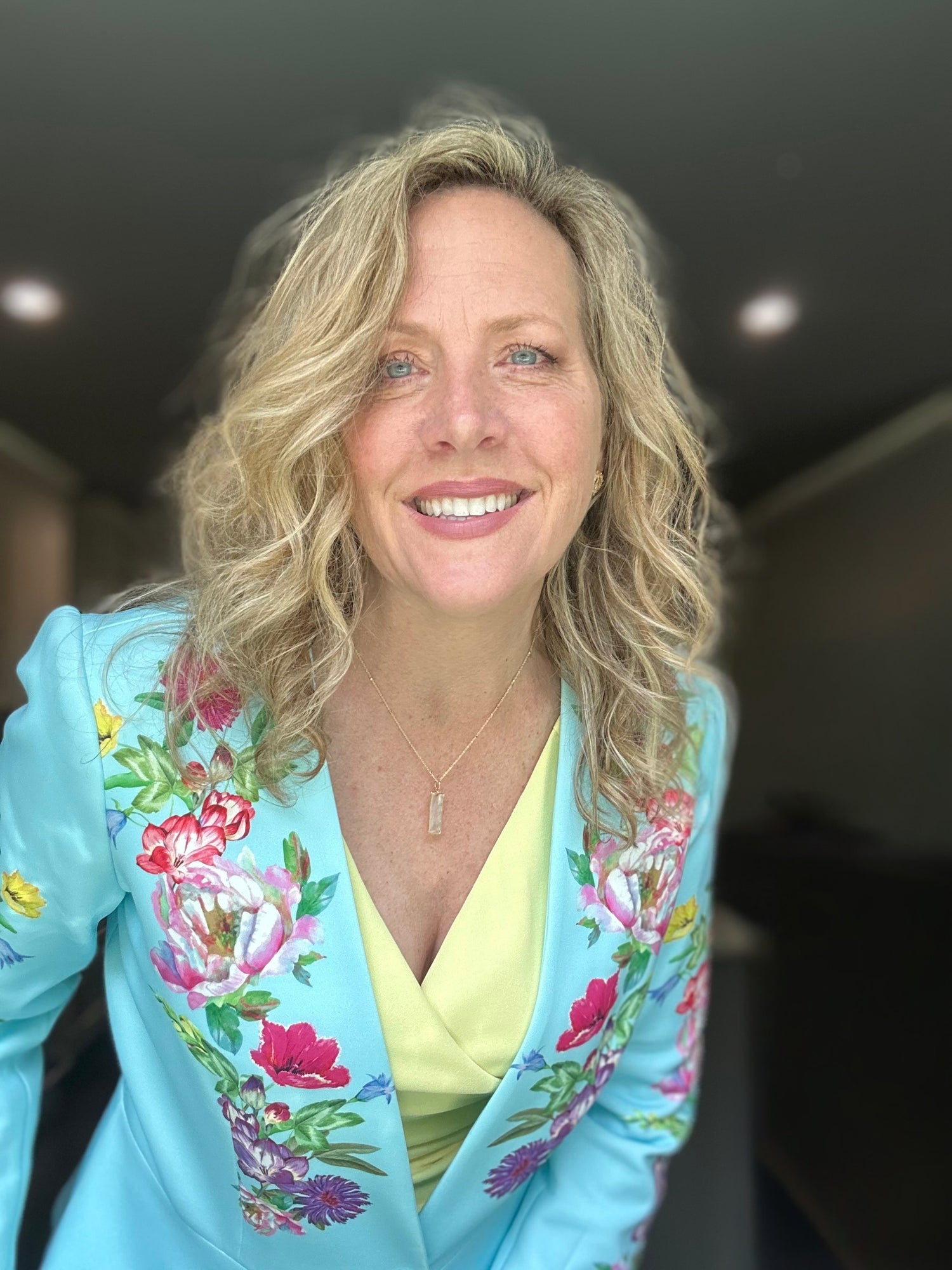 Tricia Gieseke wearing a colorful floral jacket indoors